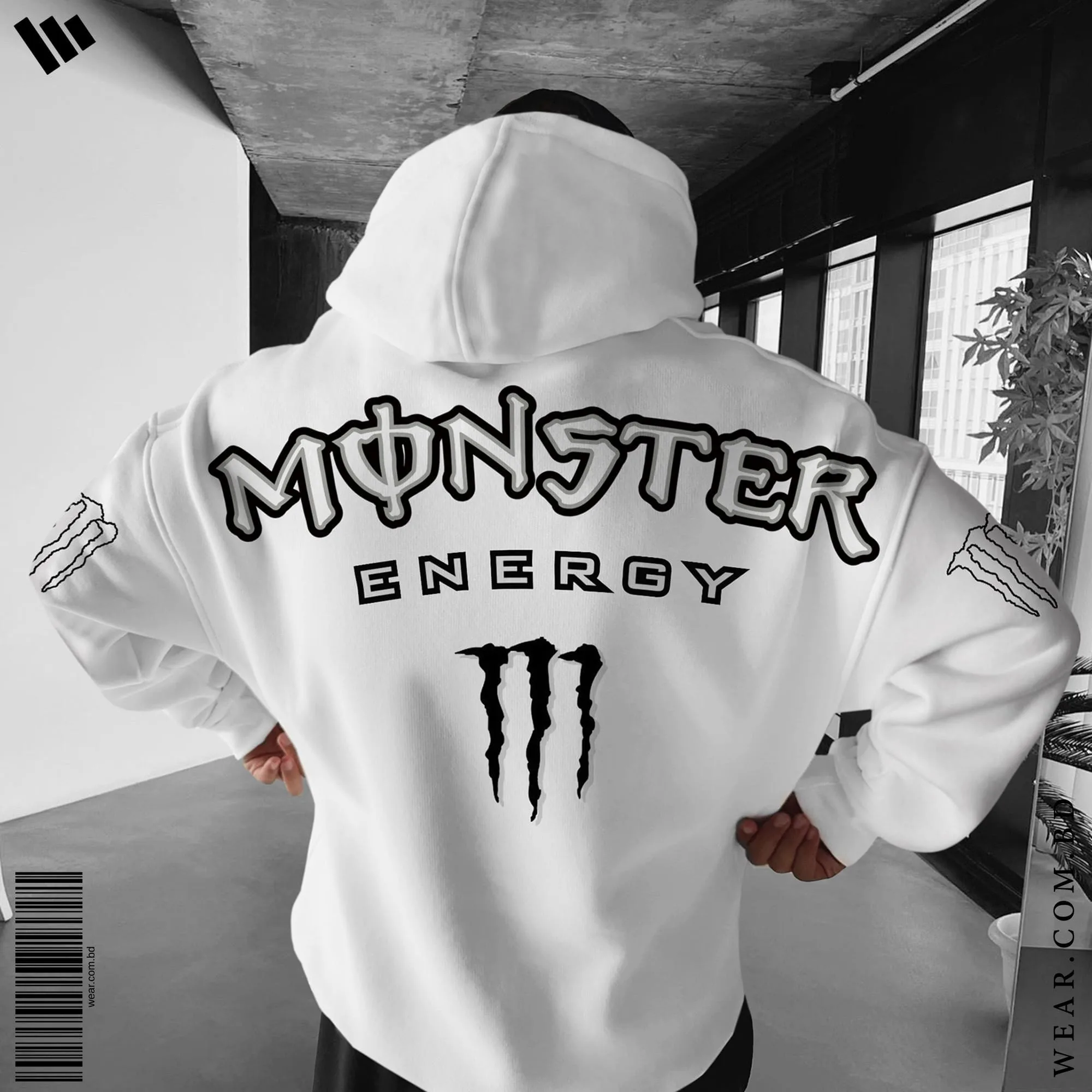 Back view of a man wearing a white oversized hoodie featuring the large Monster Energy text logo and M-claw graphic, with M-claw logos on the sleeves.