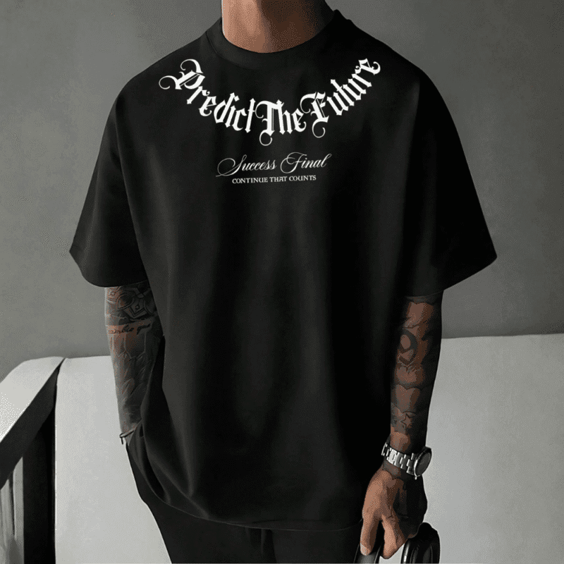 Front view of a man wearing a black oversized t-shirt with white text saying "Predict The Future" in gothic font, and "Success Final CONTINUE THAT COUNTS" below it.